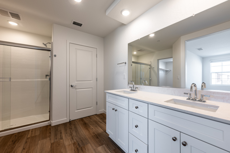 A bathroom with white cabinets.