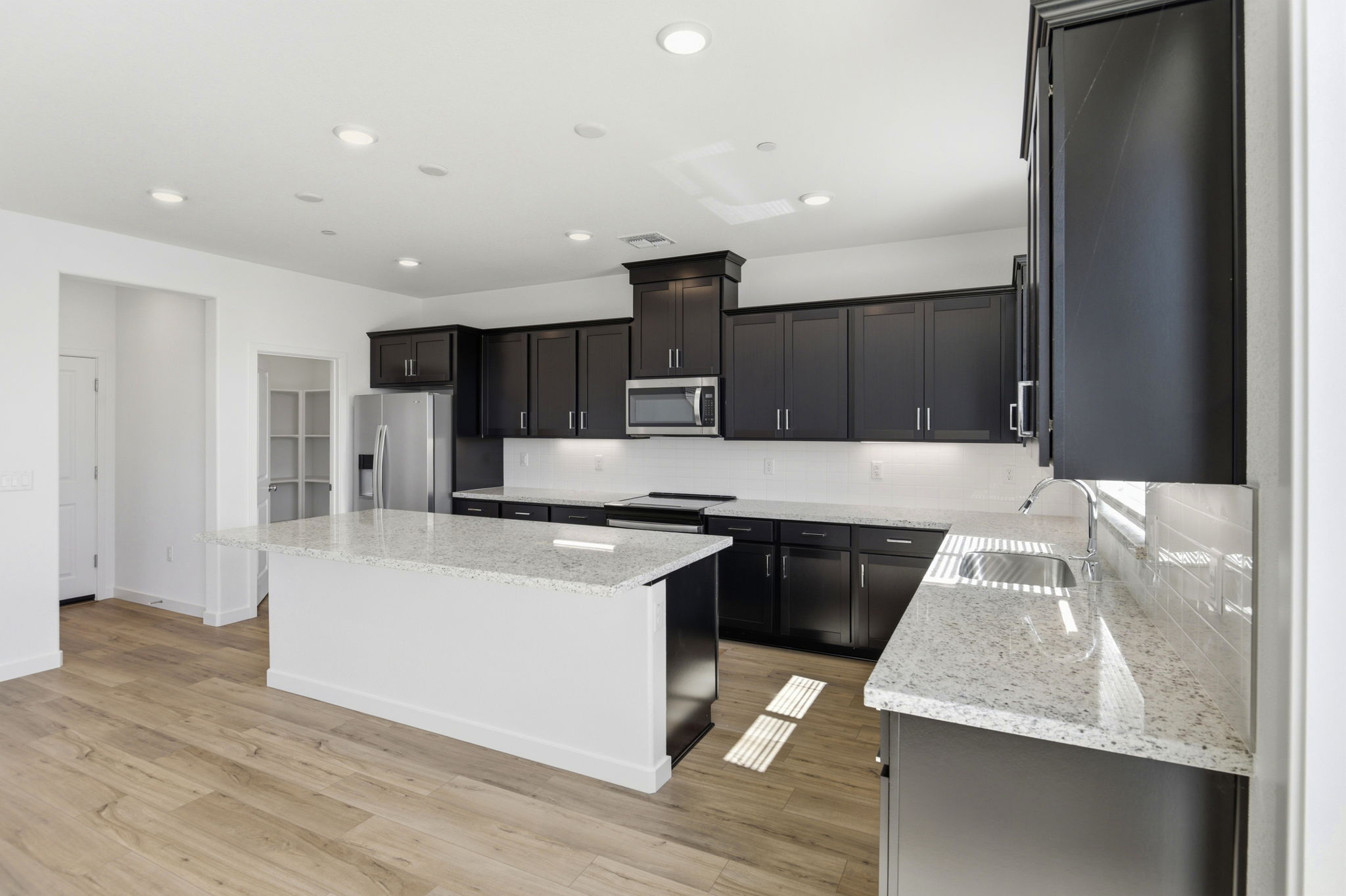 A kitchen with black cabinets.