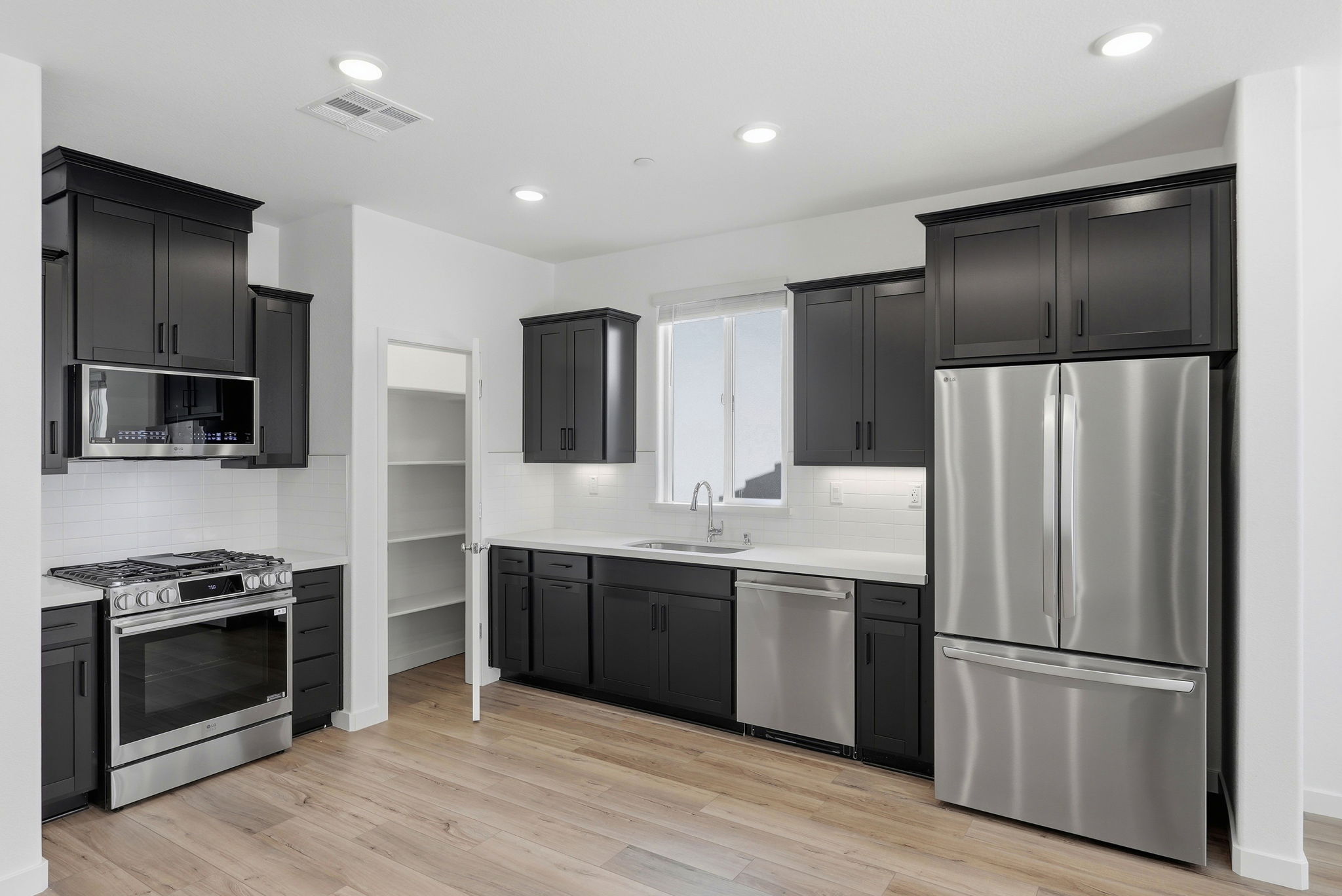 A kitchen with black cabinets.