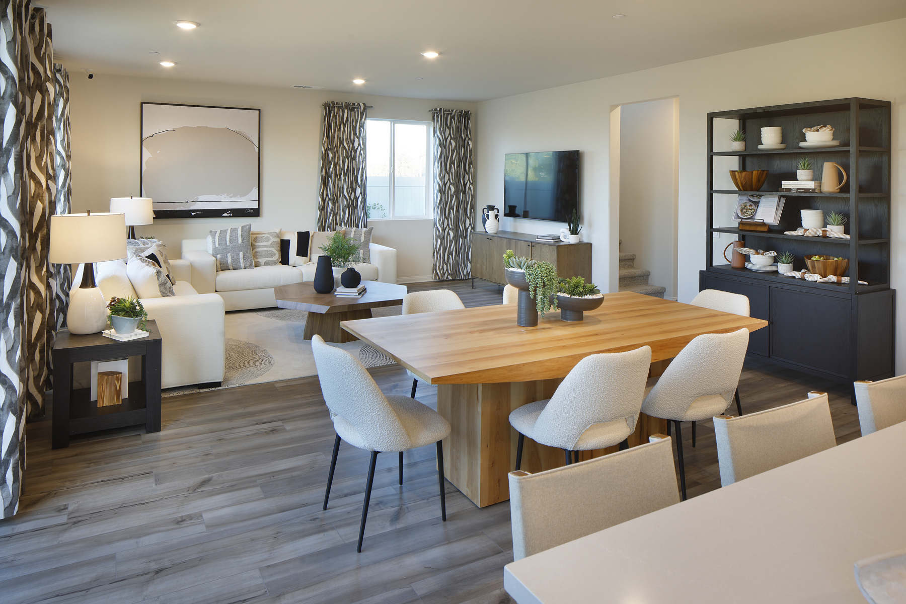 A large living room with a large table and chairs.