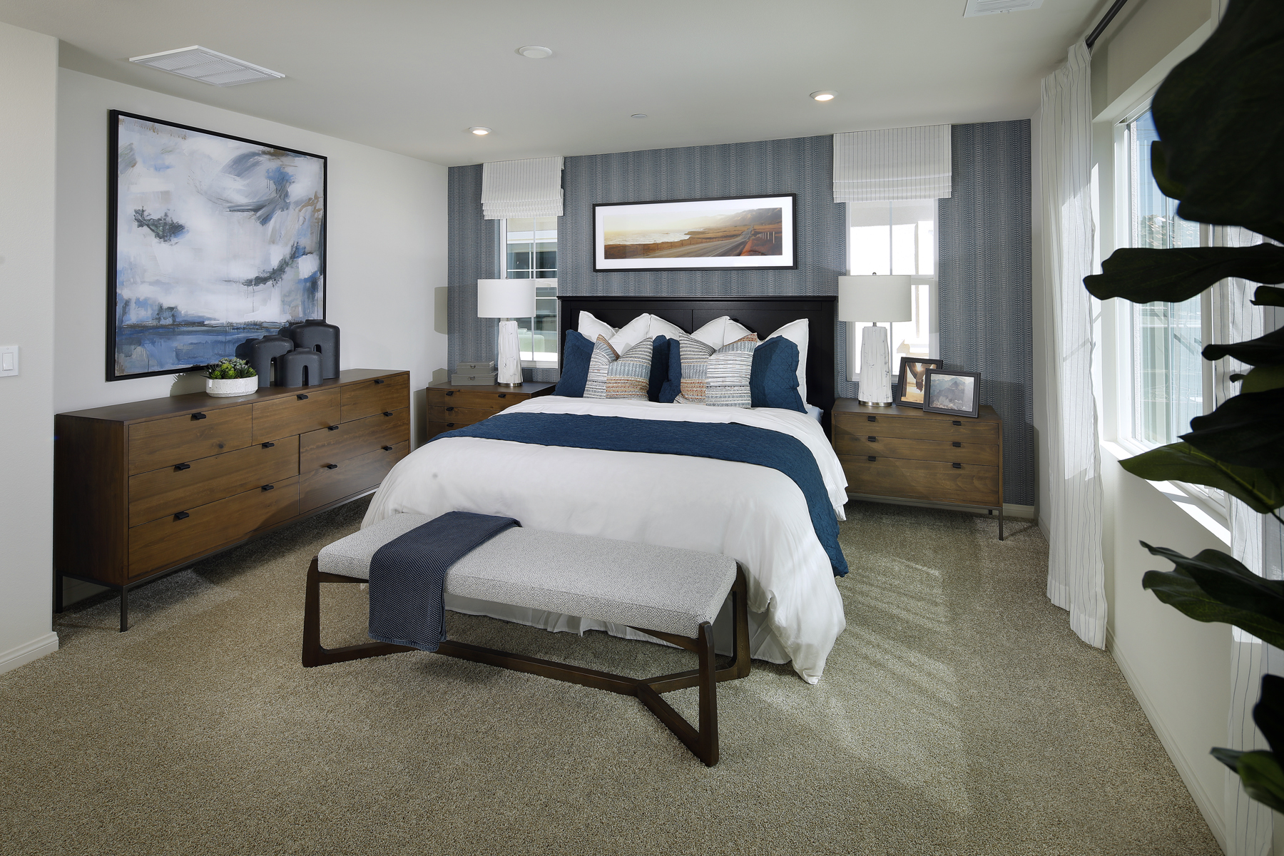 A bedroom with a bed and a bench.