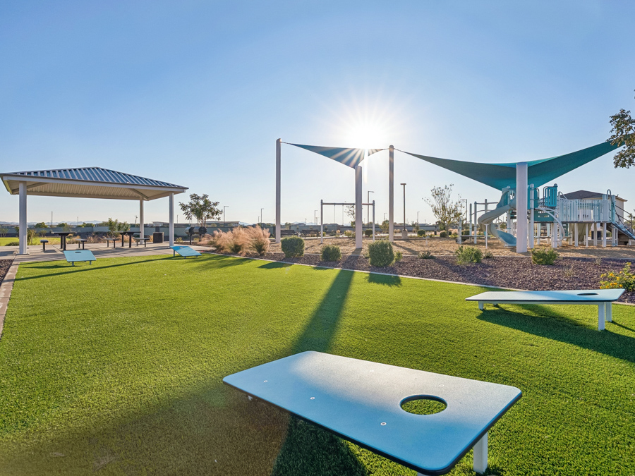 A large green lawn with a few tables and a few buildings.