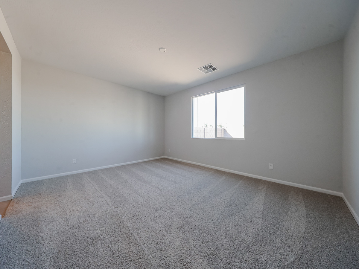 A room with a carpet and a window.