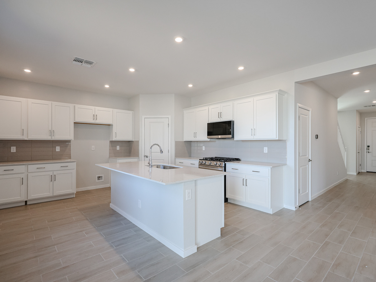 A kitchen with white cabinets.