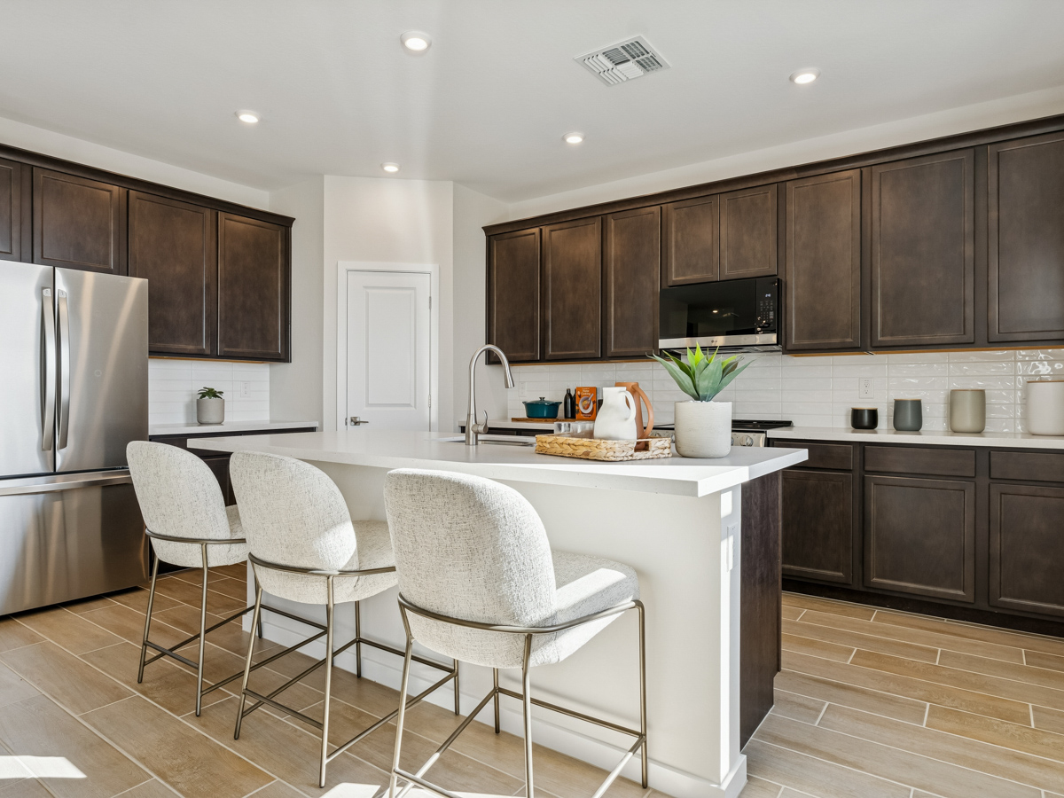 A kitchen with a white table and chairs.