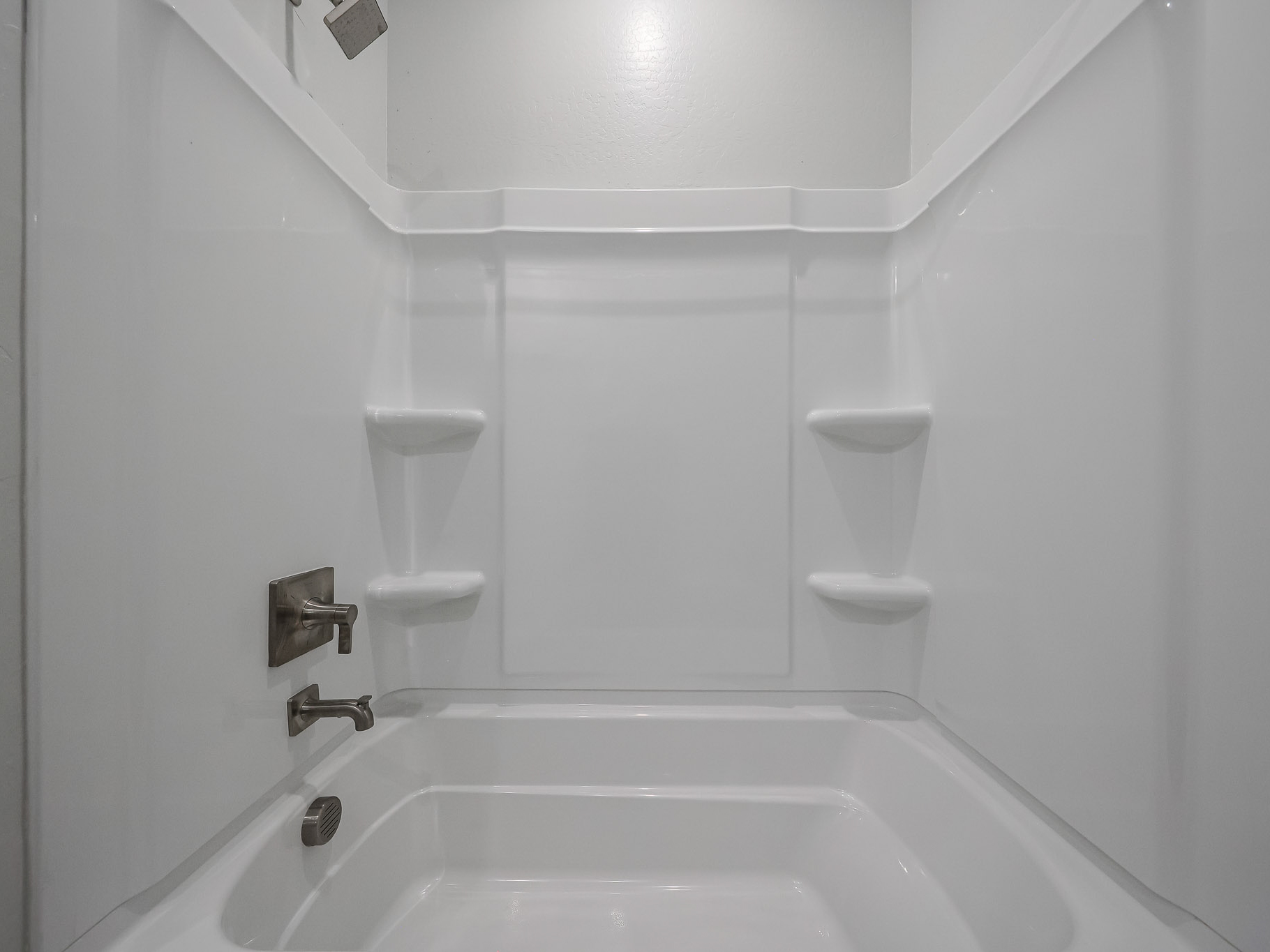 A bathtub and toilet in a bathroom.