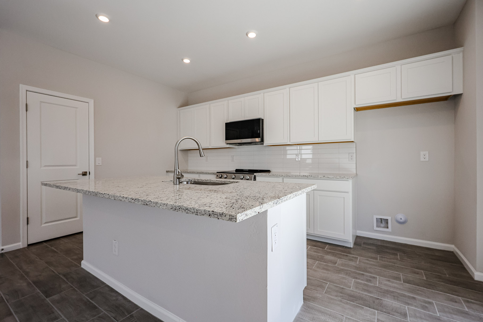 A kitchen with white cabinets.