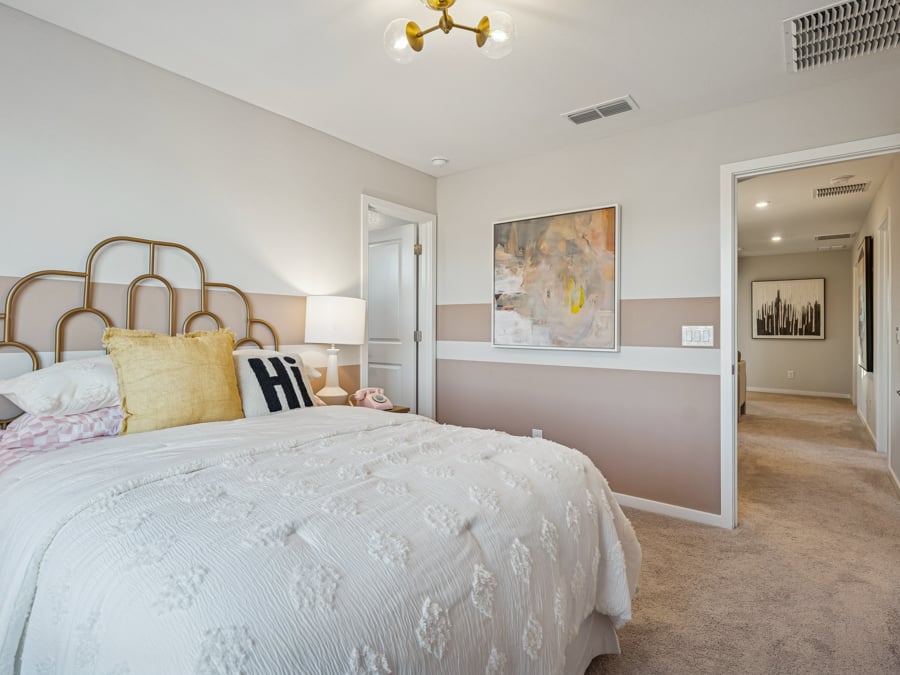 A bedroom with a bed and a lamp.