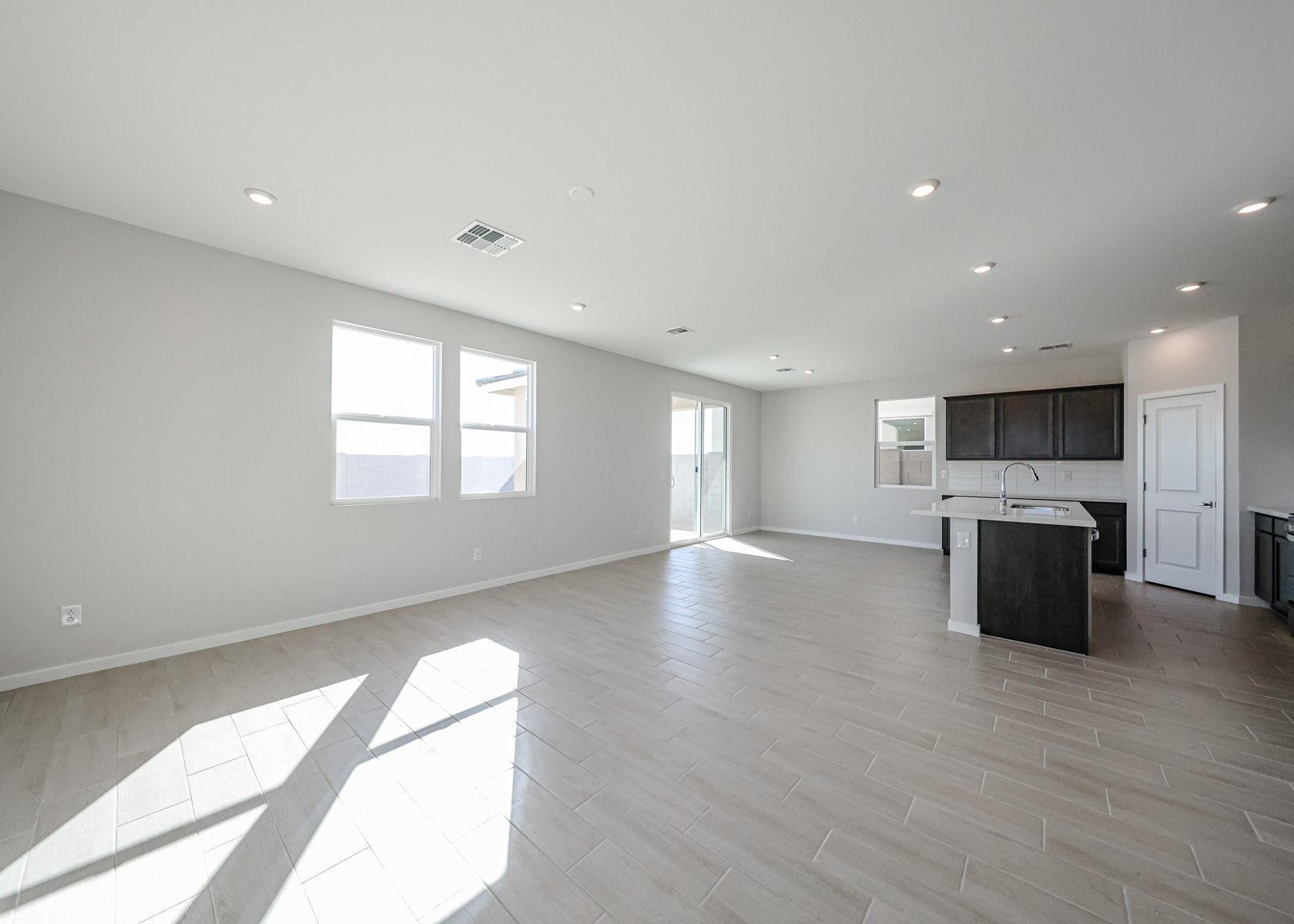 A large empty room with a wood floor and white walls.