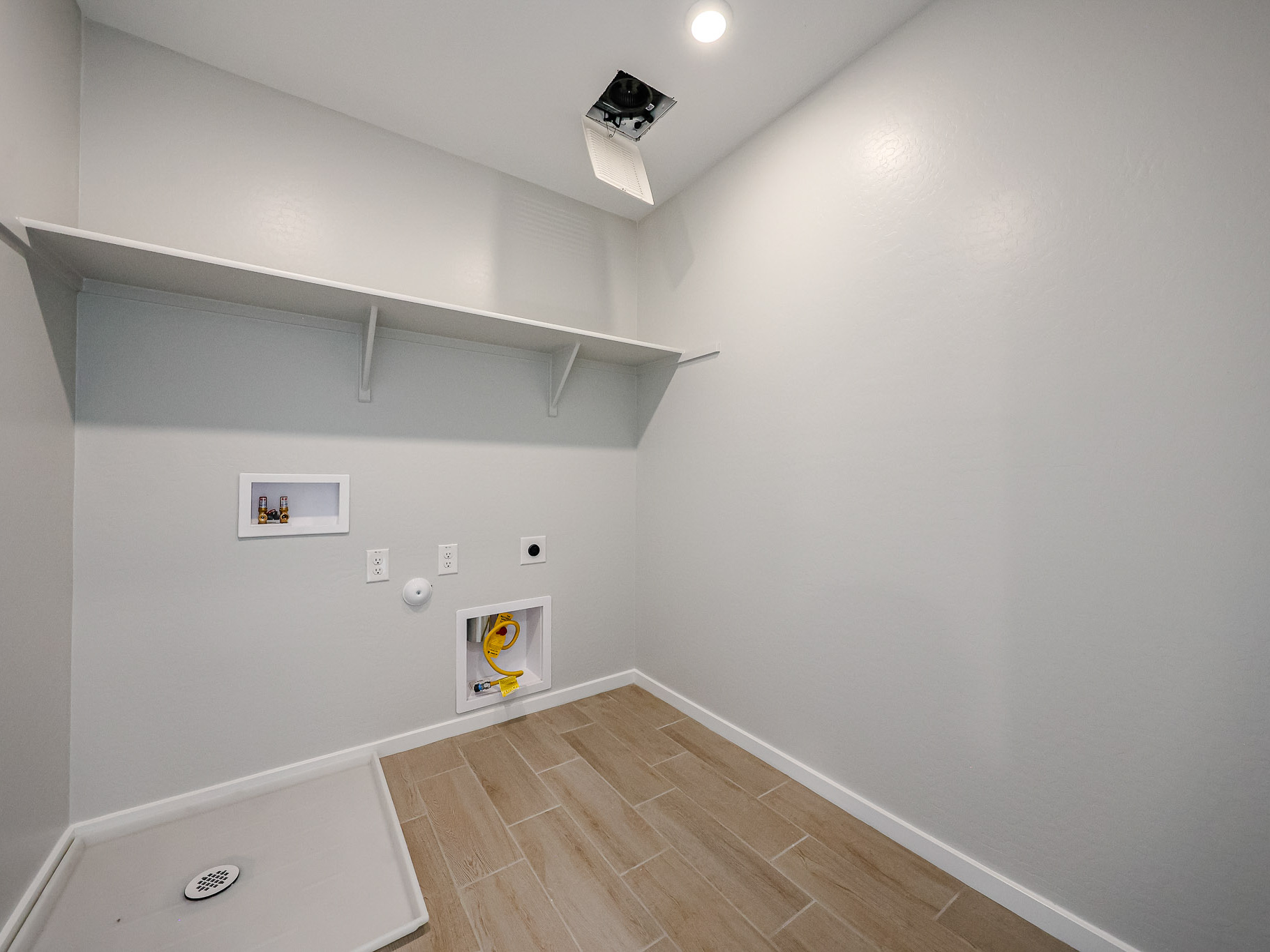 A room with a wood floor and white walls.
