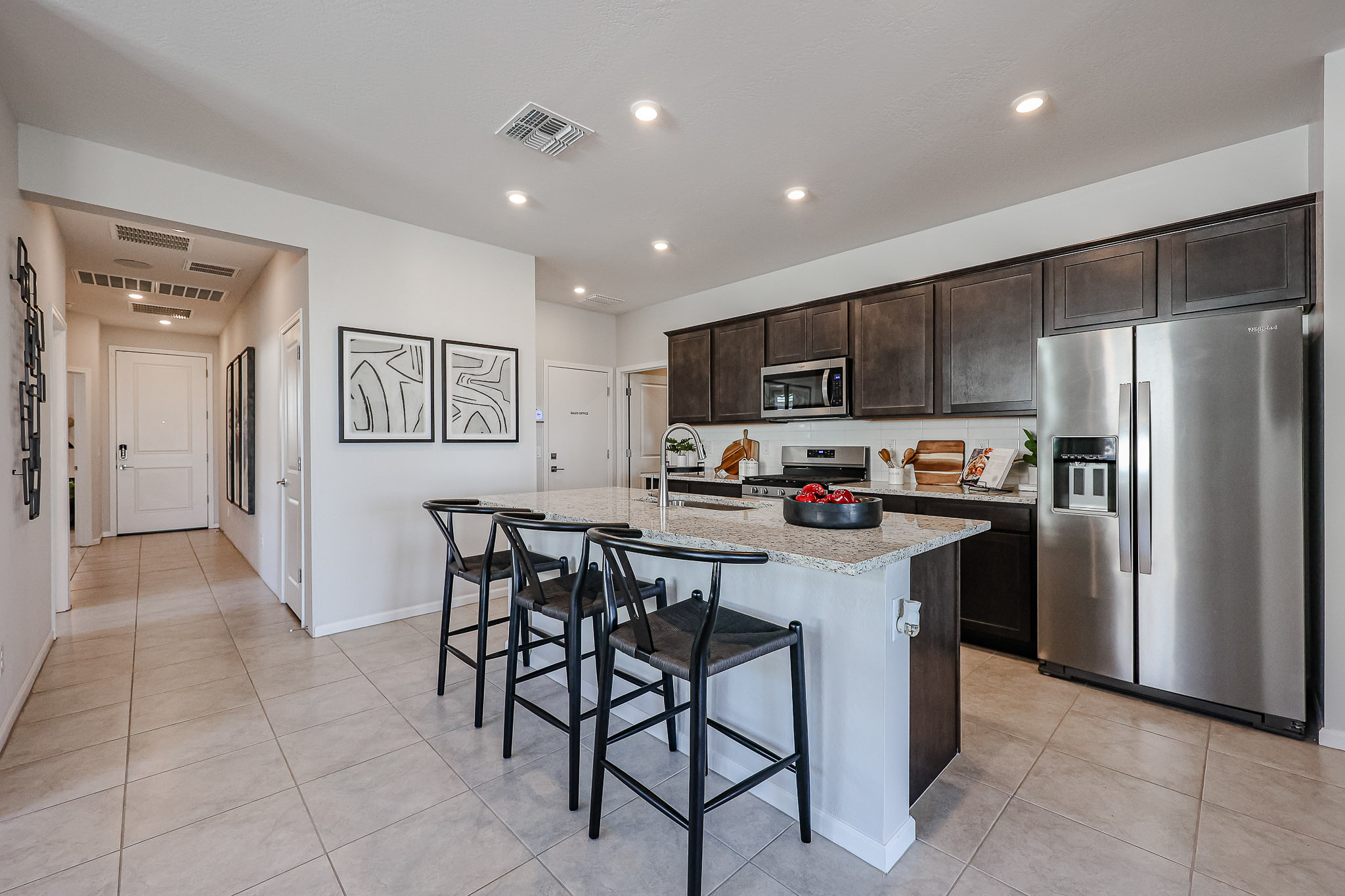 A kitchen with a bar and stools.