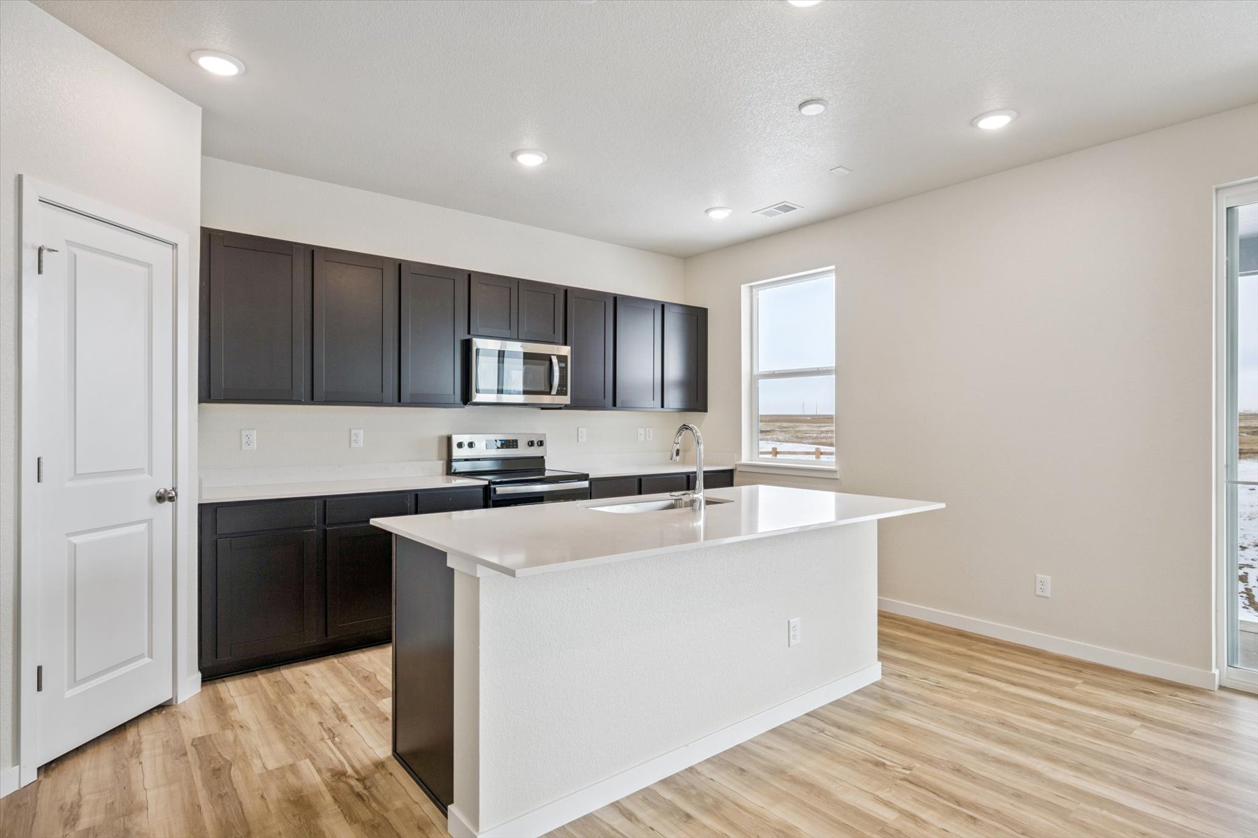 A kitchen with black cabinets.