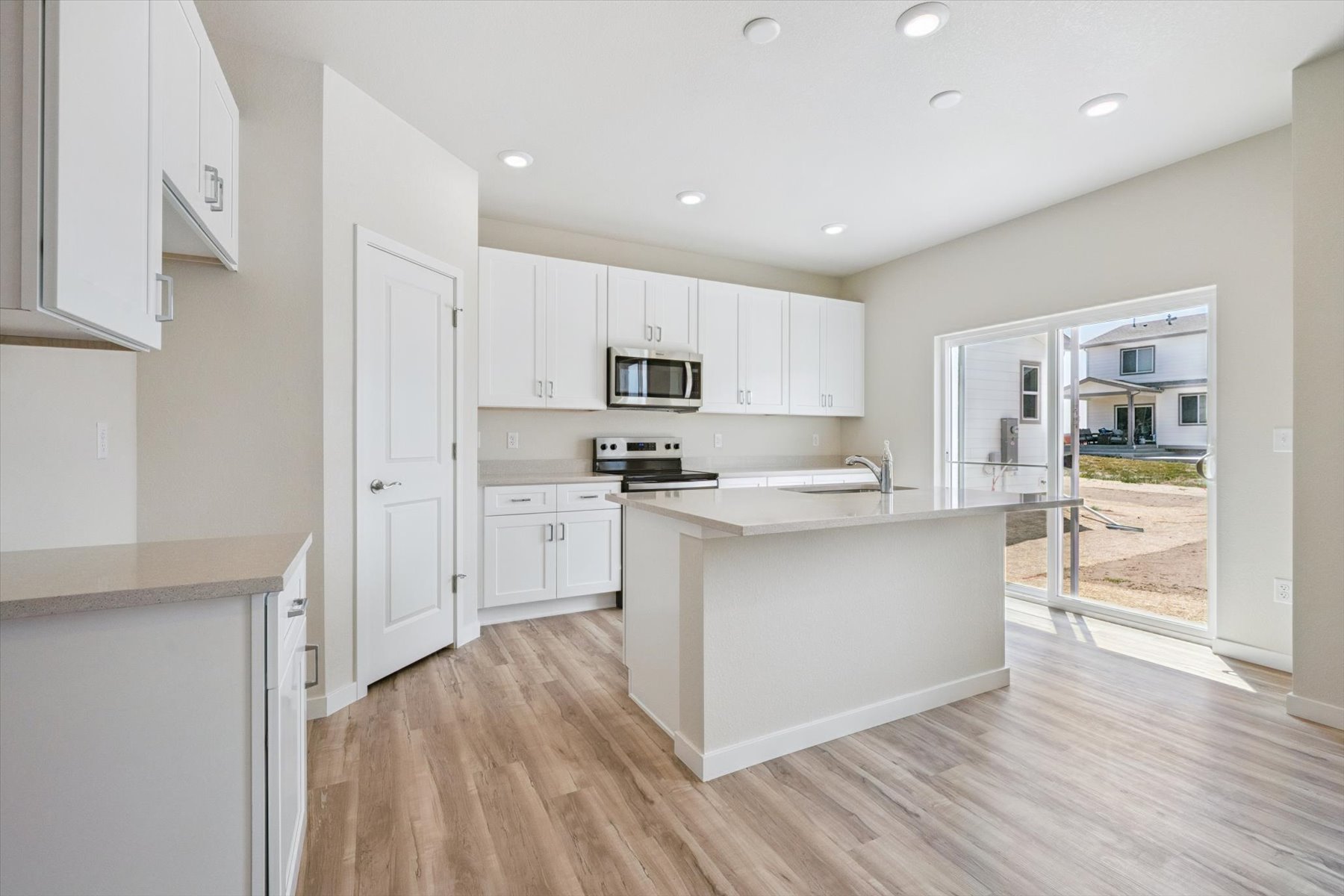 A kitchen with white cabinets.
