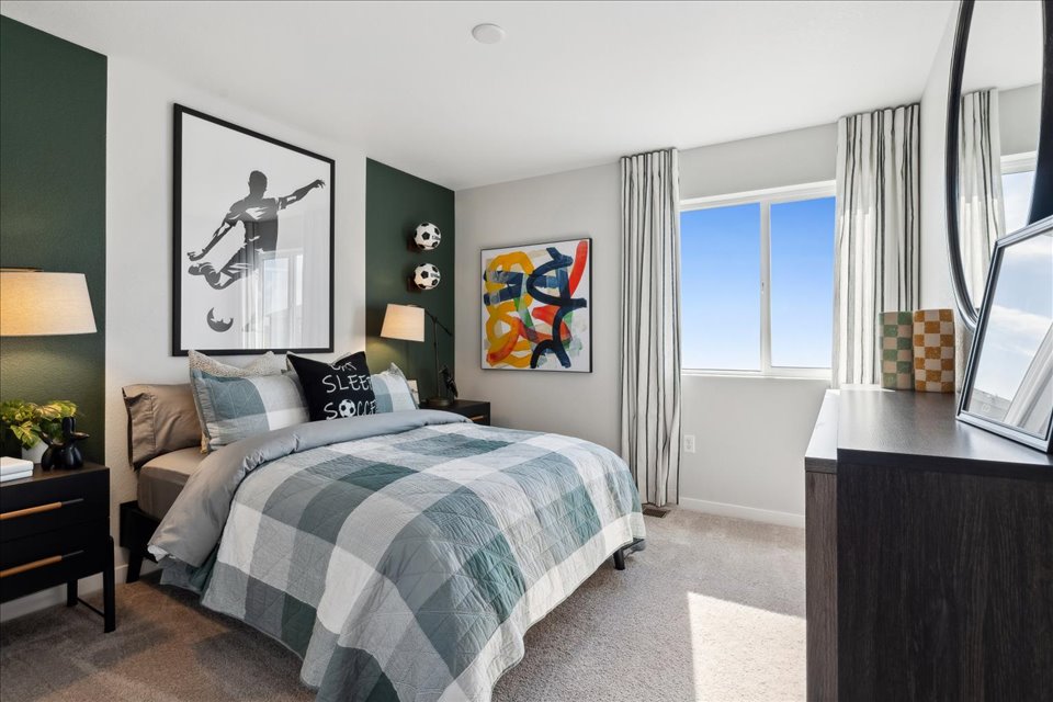 A bedroom with a bed and a desk.