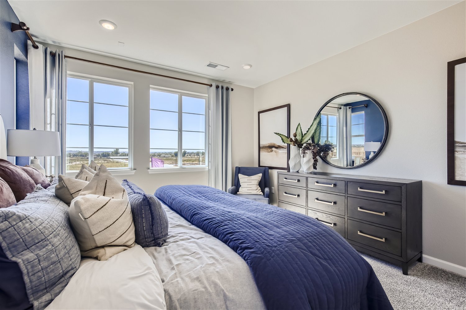 A bedroom with a large mirror.