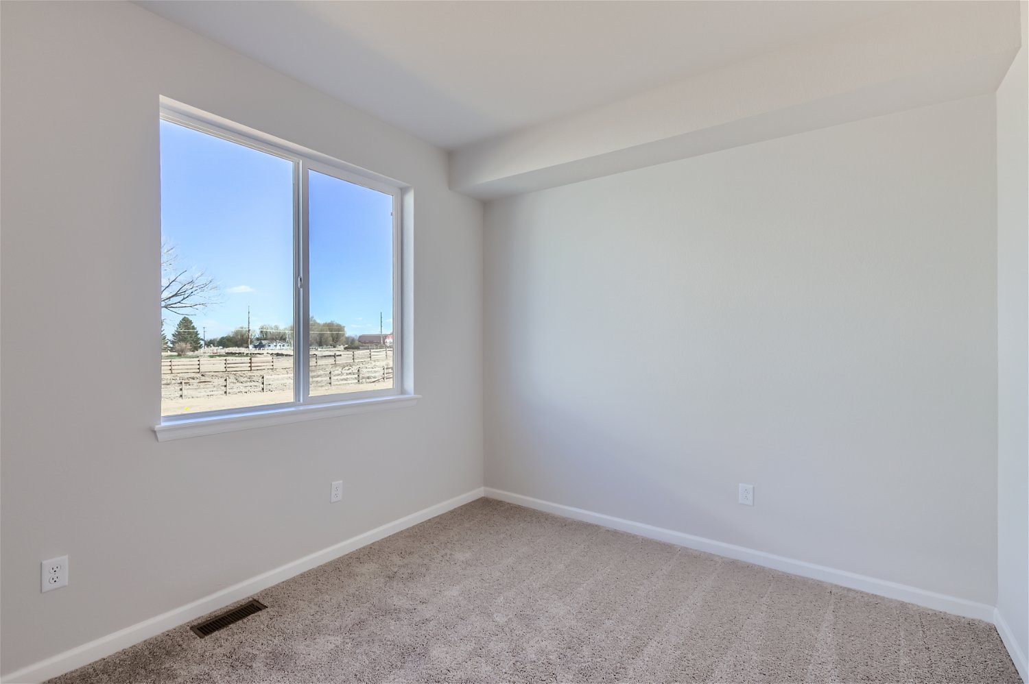 A room with a window and a carpet.