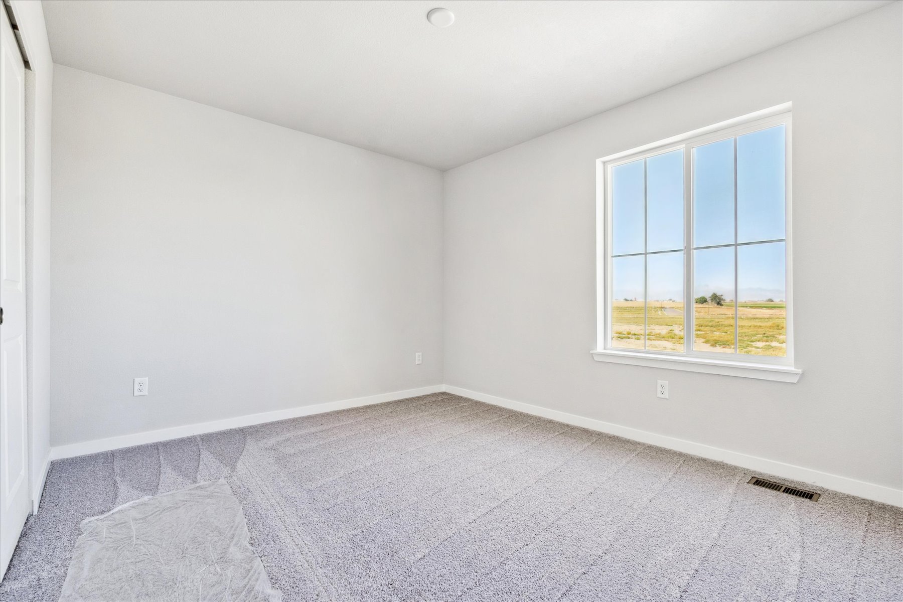 A room with a window and carpet.