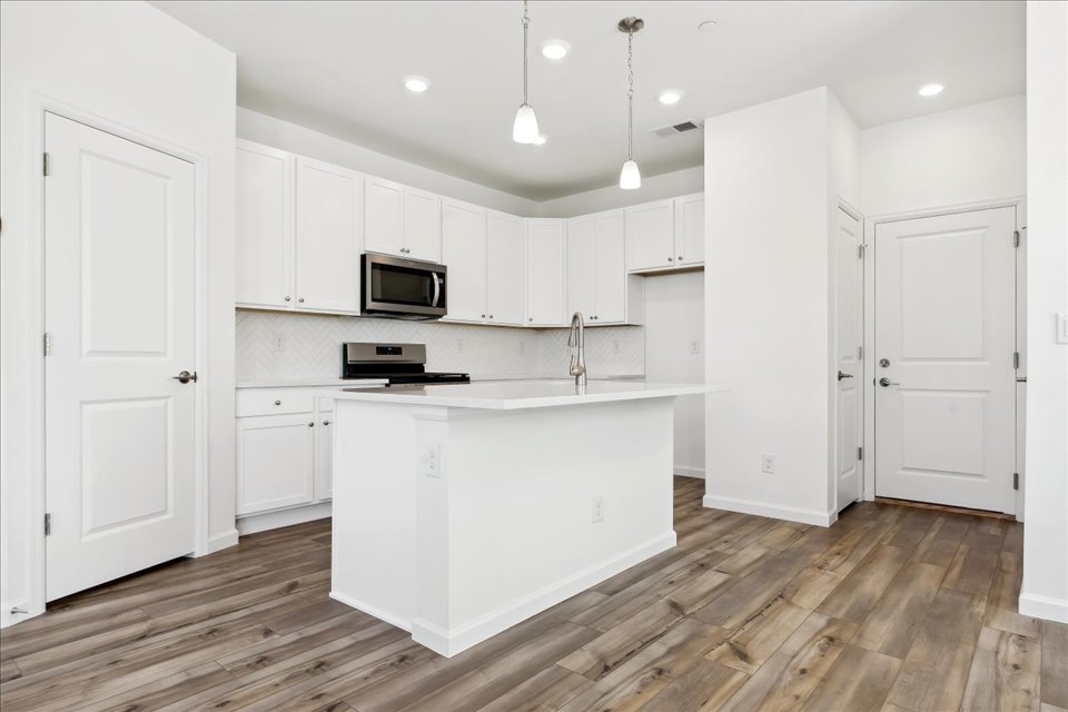 A kitchen with white cabinets.