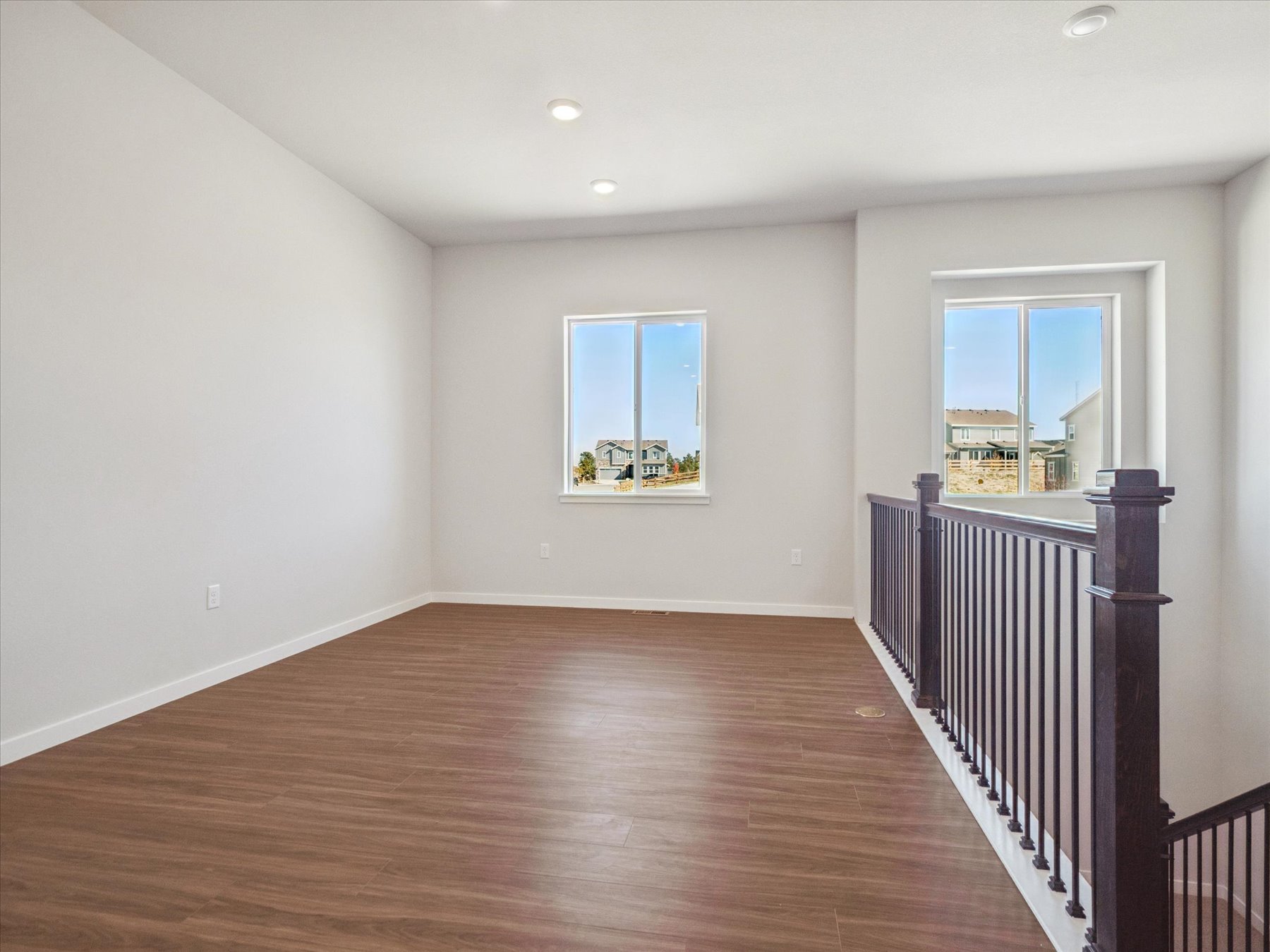 A room with a wood floor and a wood floor with a railing.