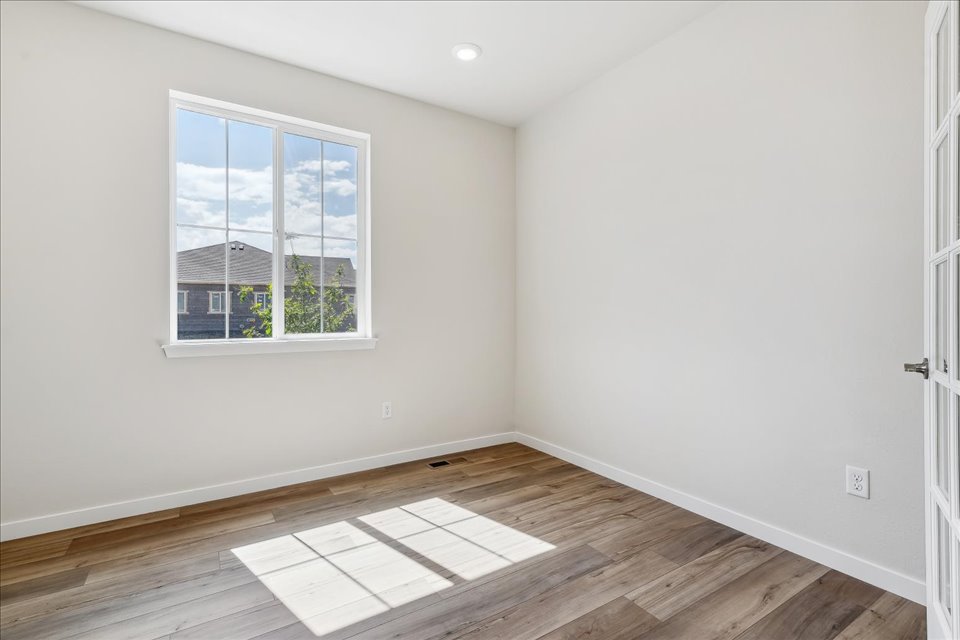 A room with a wood floor and windows.
