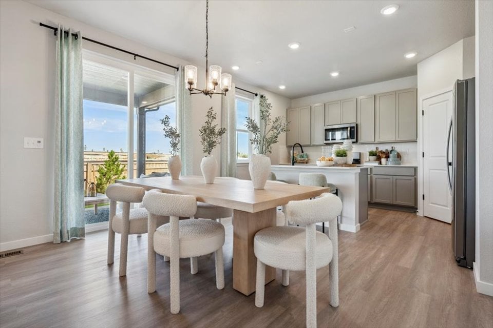 A kitchen with a dining table and chairs.