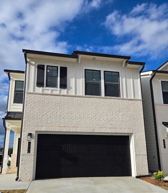 A grey house with a garage.