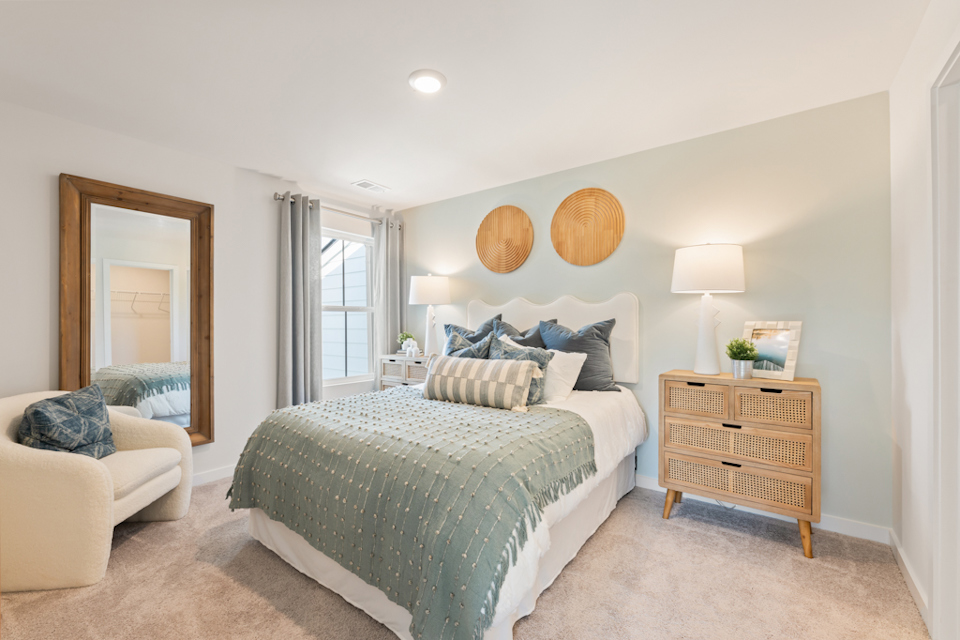 A bedroom with a bed and a mirror.