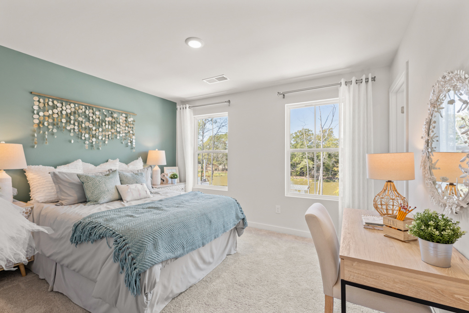 A bedroom with a bed and a table.