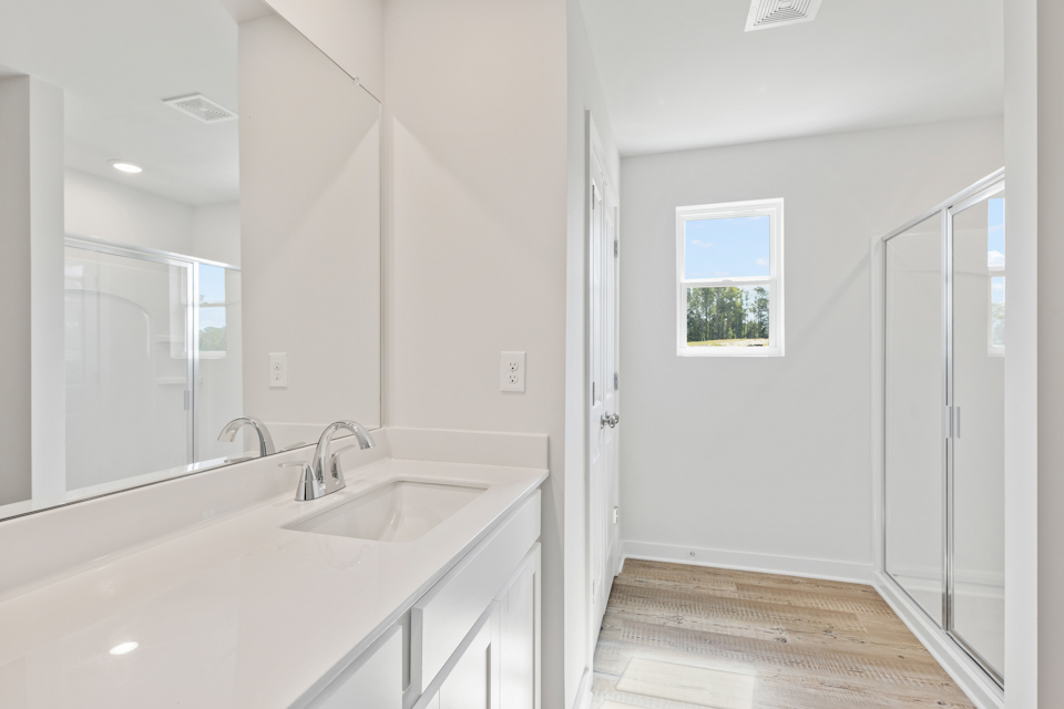 A bathroom with a sink and a shower.