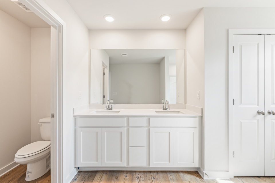 A bathroom with white cabinets.