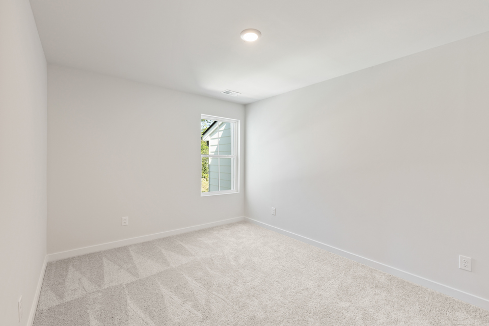 A room with a window and a carpet.