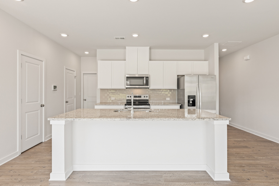 A kitchen with white cabinets.