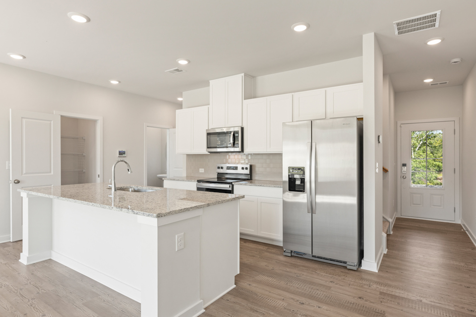 A kitchen with white cabinets.
