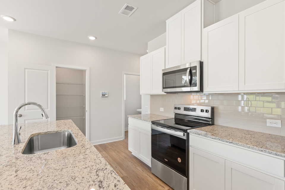 A kitchen with white cabinets.