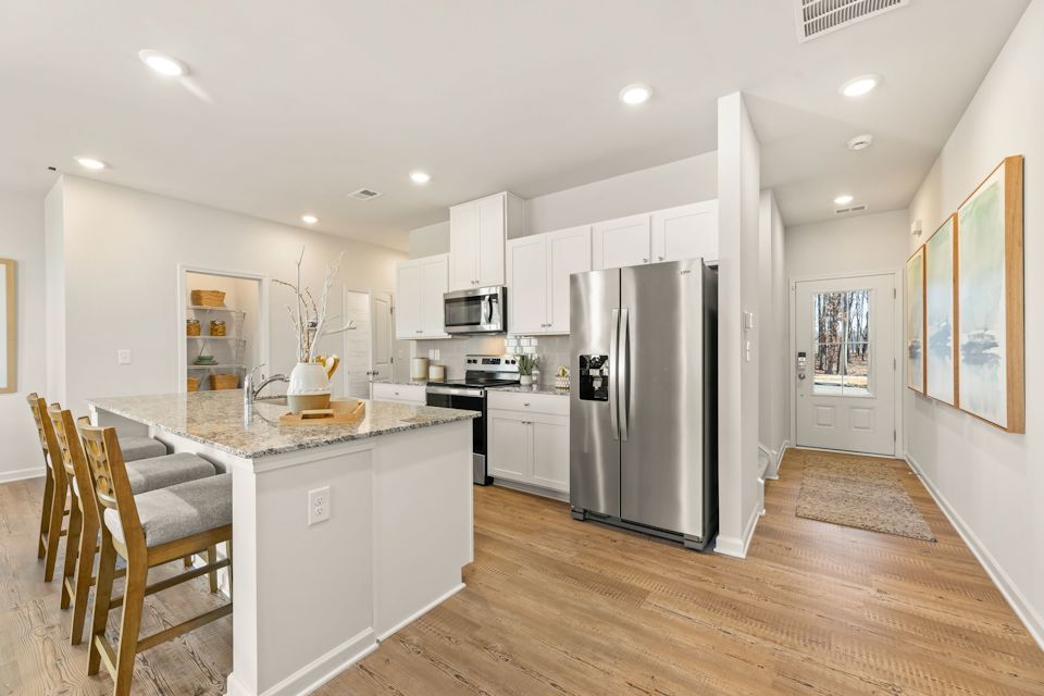 A kitchen with white cabinets.