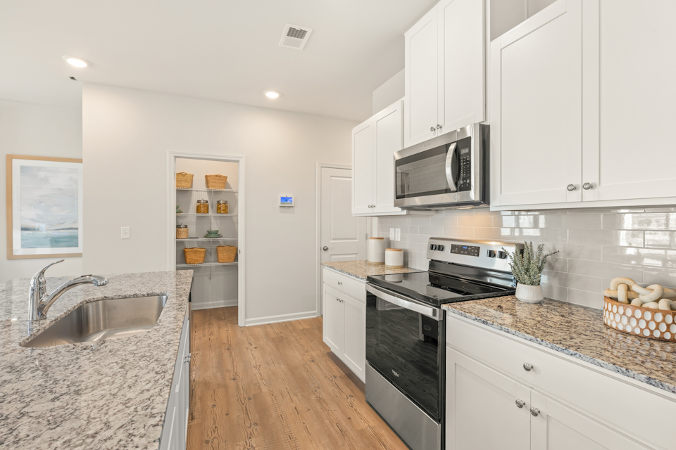 A kitchen with white cabinets.