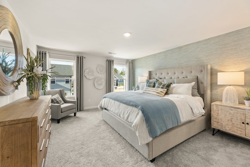 A bedroom with a bed and a chair.