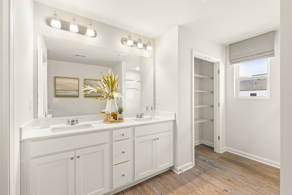A bathroom with white cabinets.