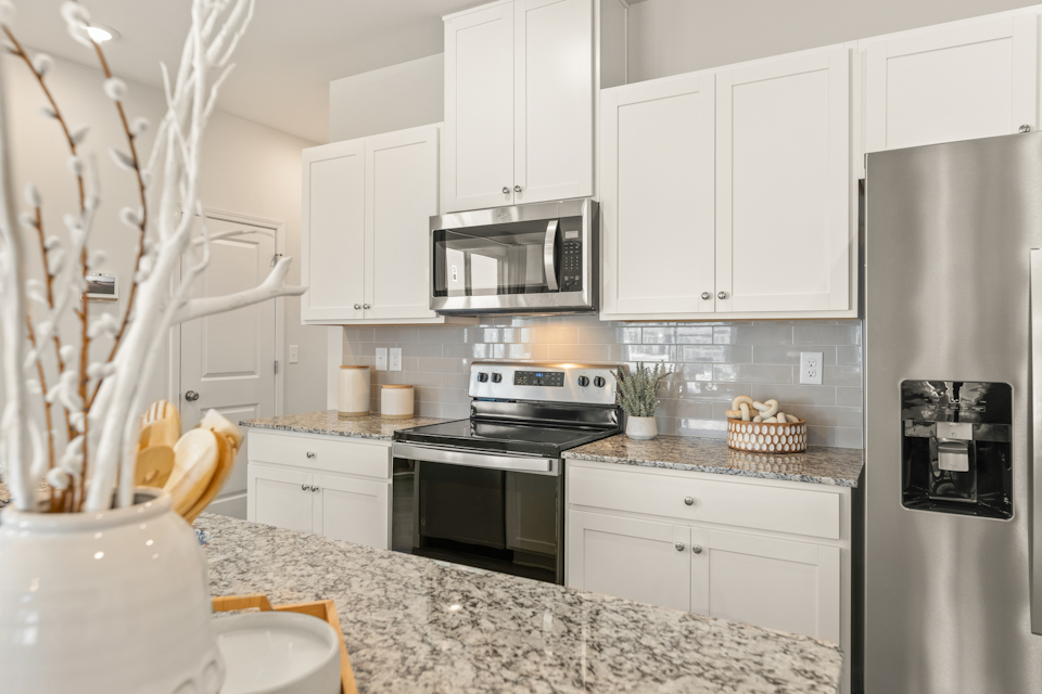 A kitchen with white cabinets.