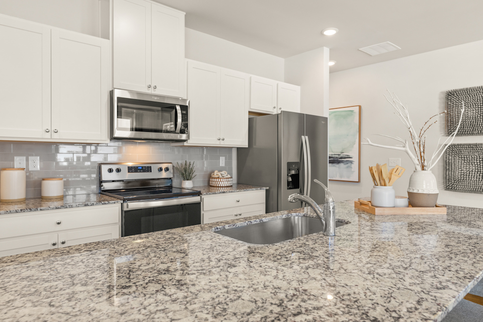 A kitchen with white cabinets.