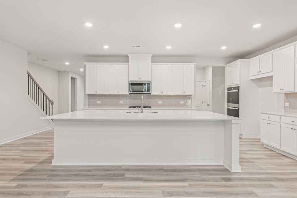 A kitchen with white cabinets.