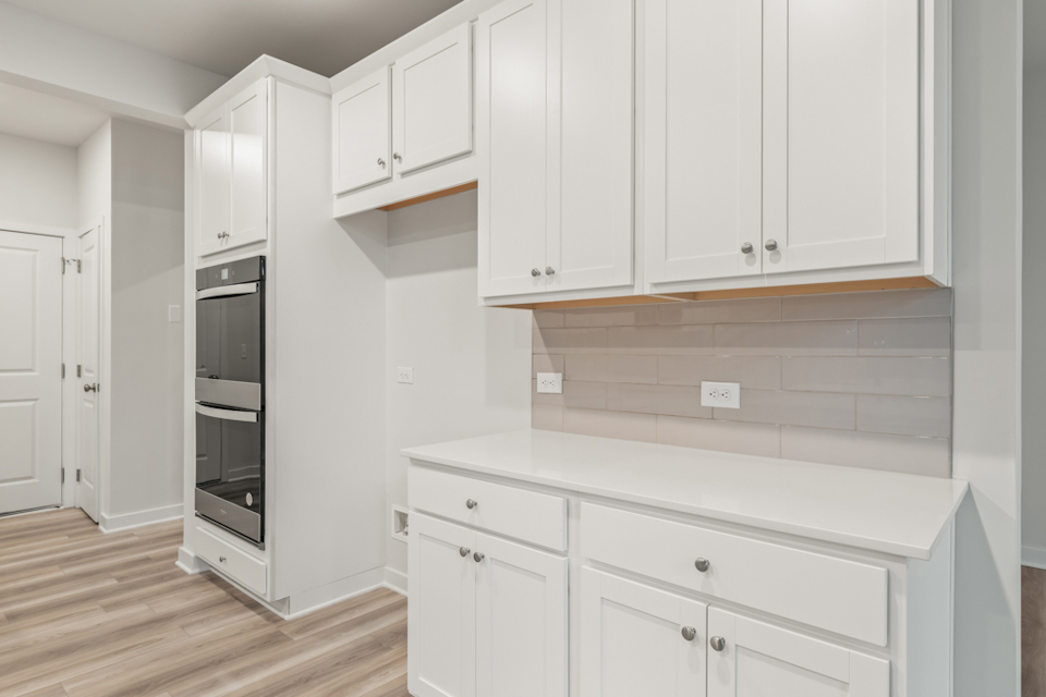 A kitchen with white cabinets.