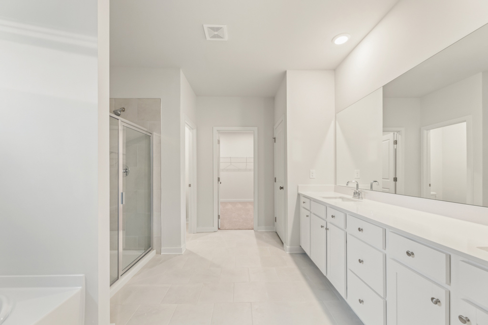 A bathroom with white cabinets.