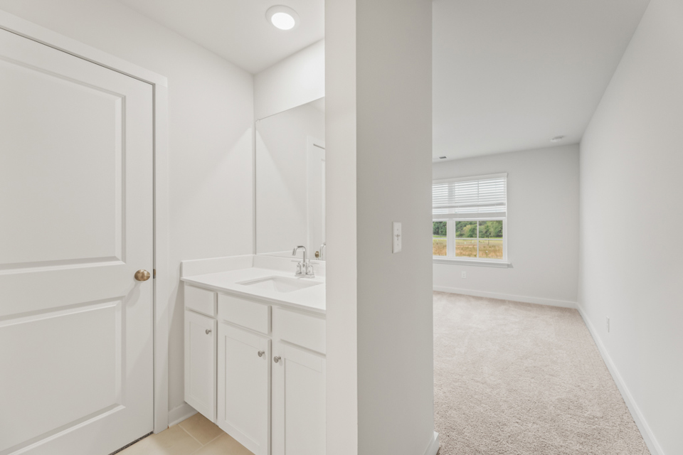 A bathroom with white cabinets.