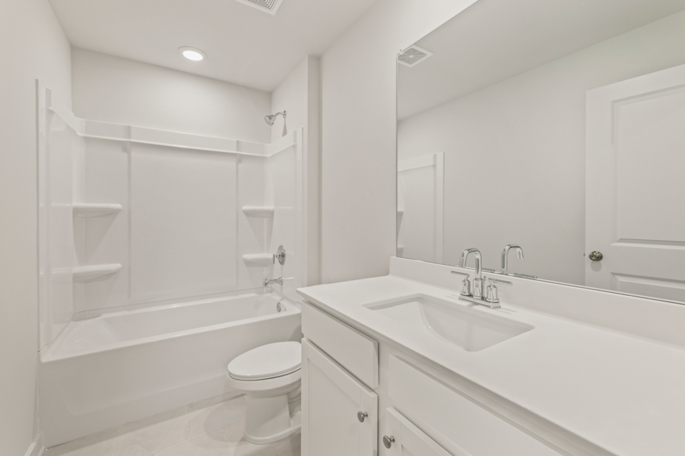 A bathroom with a tub sink and toilet.
