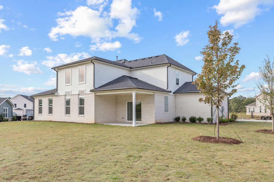 A house with a tree in the front yard.