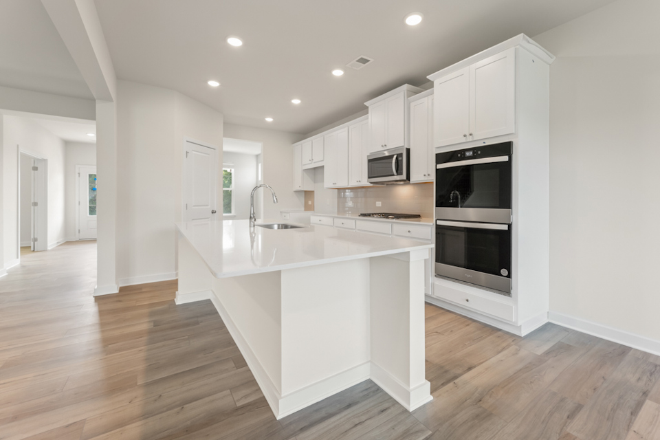 A kitchen with white cabinets.