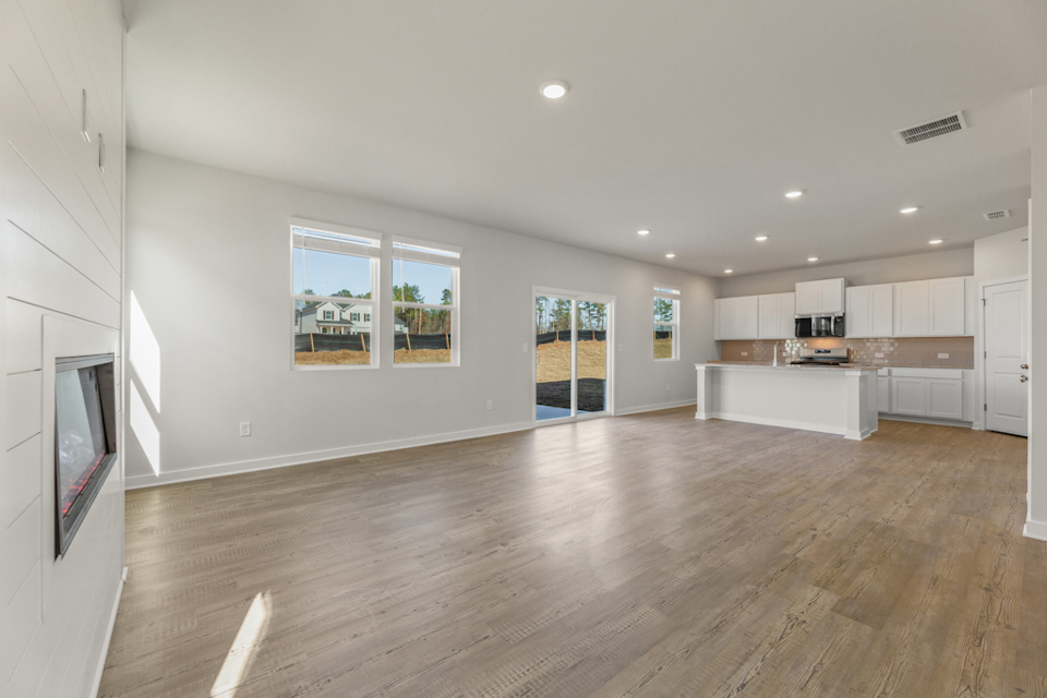 A large empty room with a wood floor and white walls.