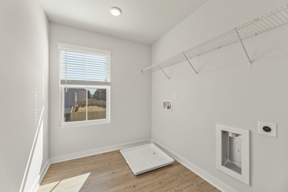 A room with a window and a wood floor.