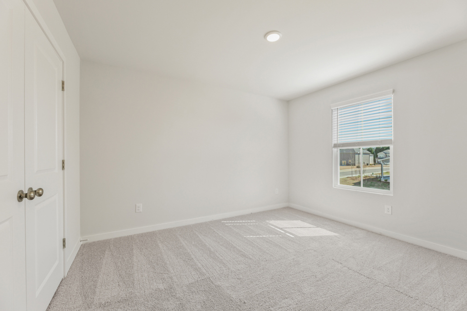 A room with a window and a rug in it.